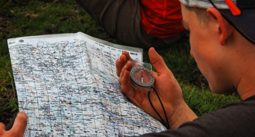 a student uses a compass and map on an outward bound gap year expedition